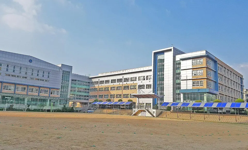 넓은 운동장 뒤로 보이는 설화고등학교 교사동과 체육관