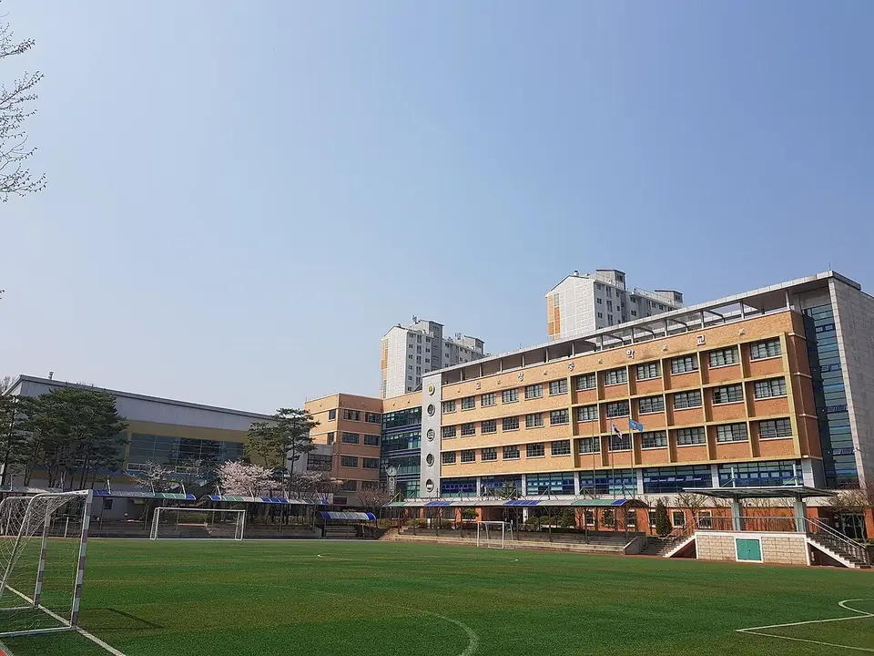 인조잔디 운동장 너머로 보이는 고창중학교 건물과 뒤쪽 아파트