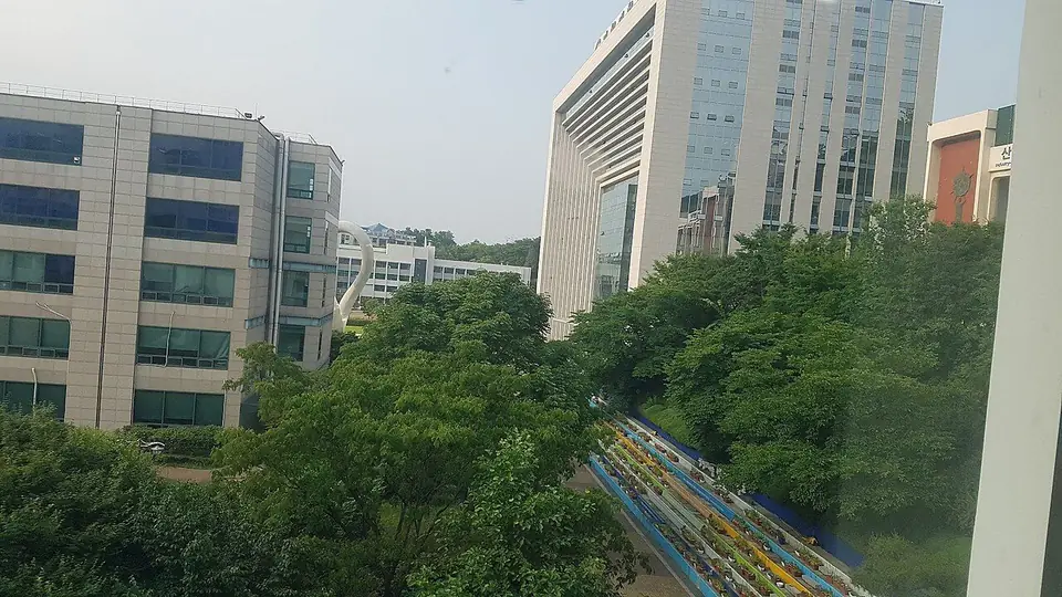 초록 나무 사이로 보이는 가천대학교 글로벌캠퍼스의 높은 건물들