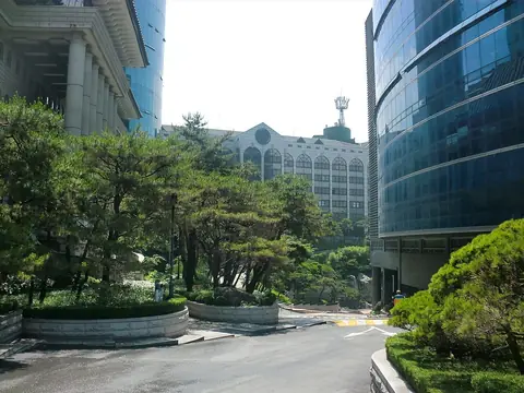 소나무 길 양옆으로 기와지붕 건물과 파란 유리 건물이 서 있는 서경대학교 캠퍼스
