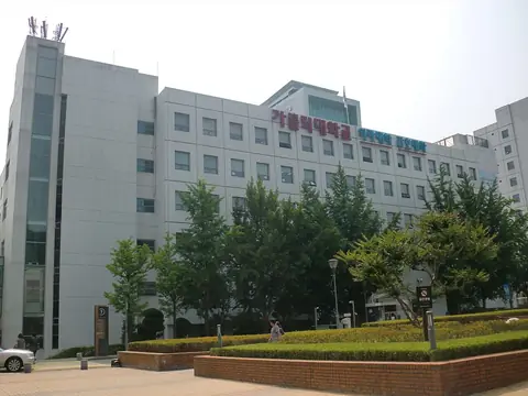 '가톨릭대학교 의과대학 간호대학' 글자가 붙은 흰 건물과 앞쪽 나무·화단